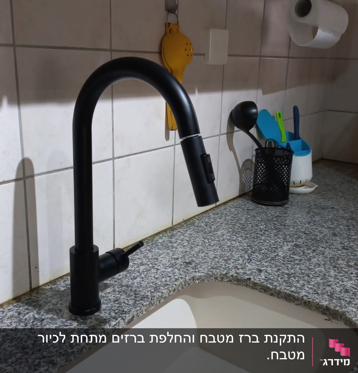 ברז שחור מעל כיור מטבח עם ניקוז